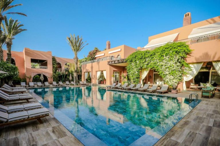 Piscina exterior con tumbonas y jardín tropical del Tikida Golf Palace en Marrakech