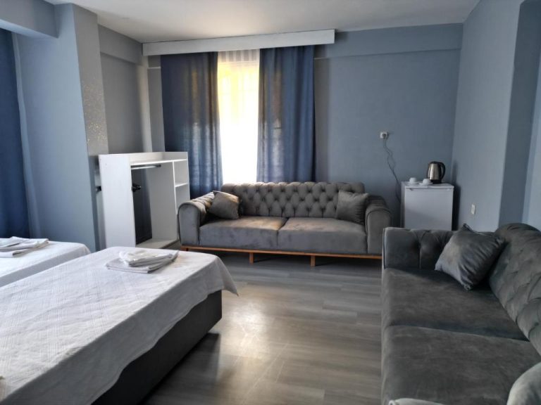 Habitación suite del Akman City Hotel con sofás capitoné grises, cama doble y decoración en tonos azules