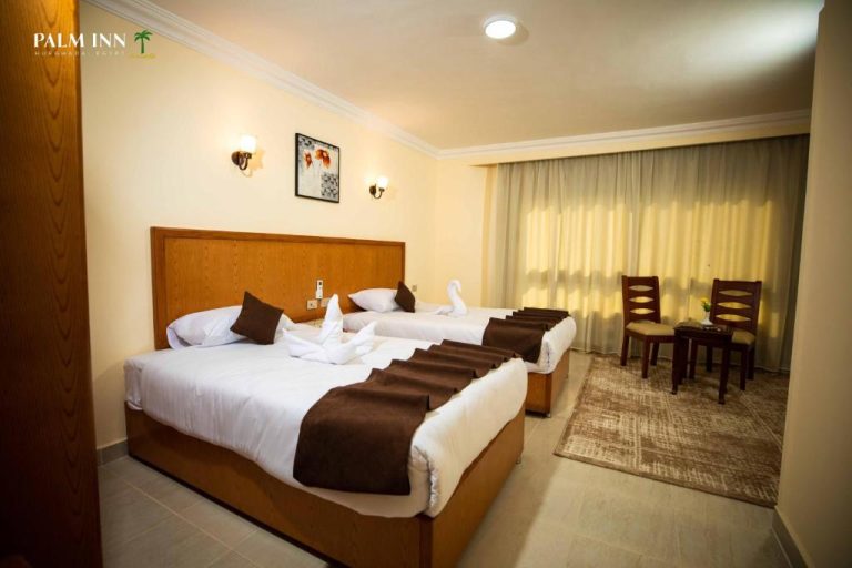 Habitación triple con dos camas dobles y decoración elegante en Palm Inn Hotel Hurghada, Egipto