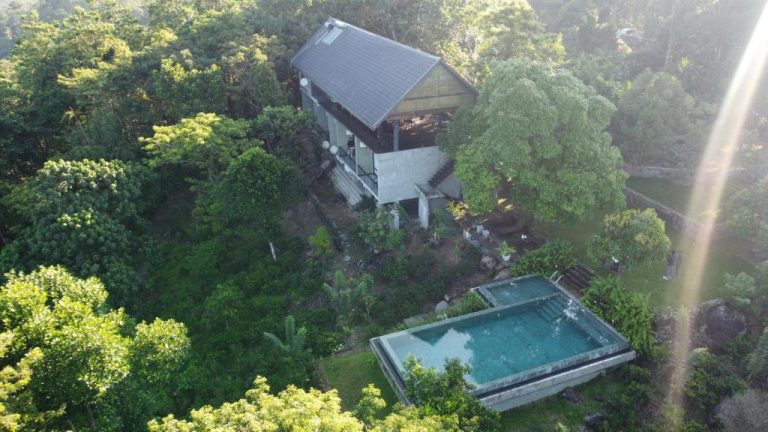 Vista aérea de la piscina exterior rodeada de vegetación tropical en AHAS GAWWA Eco Lodge
