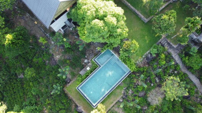 Vista aérea de la piscina infinita rodeada de vegetación tropical en AHAS GAWWA Eco Lodge