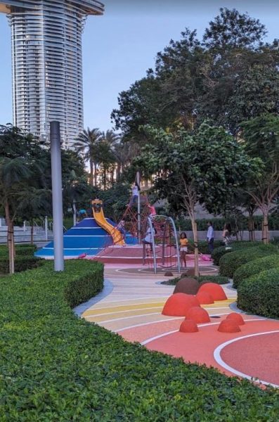 Zona de juegos infantil colorida con toboganes y árboles en apartamento de lujo cerca del Dubai Mall y Burj Khalifa