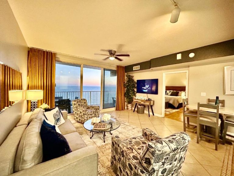 Sala de estar con vista al mar al atardecer en condo frente a la playa de Panama City Beach