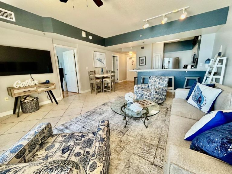 Amplio salón con decoración costera azul y blanca en condo beachfront de Panama City Beach