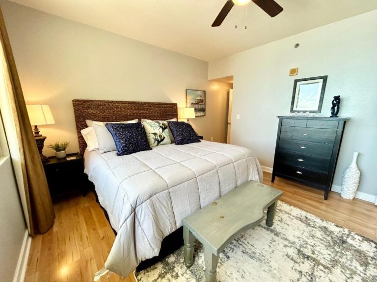 Habitación principal con cama king size y cabecero de mimbre en condo frente al mar en Panama City