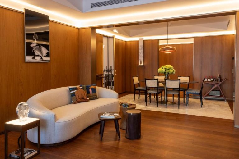 Salón y comedor de suite de lujo en Rosewood São Paulo con sofá curvo y decoración contemporánea