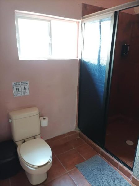 Baño privado con ducha de mampara y sanitario en Habitaciones Dos Antonios