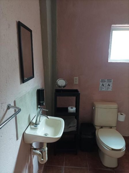 Baño completo con lavabo, inodoro y espejo en Habitaciones Dos Antonios