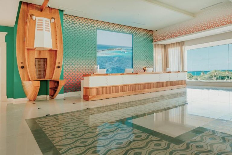 Recepción y lobby con diseño náutico y vistas al mar del JOIA Aruba by Iberostar