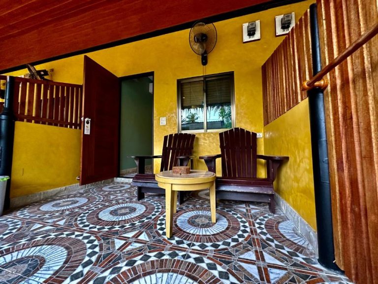 Terraza exterior con sillas de madera y suelo de mosaico en Soul of Lanta, Koh Lanta