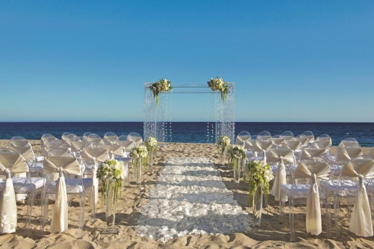 Ceremonia de boda en la playa del Secrets Puerto Los Cabos Golf & Spa con altar de cristal y vistas al mar