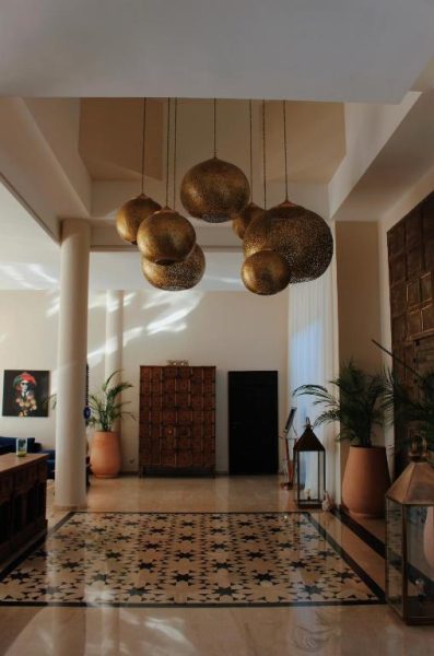 Recepción con lámparas doradas árabes y suelo de mosaico del Maison Kenoosha Boutique Hotel & Spa