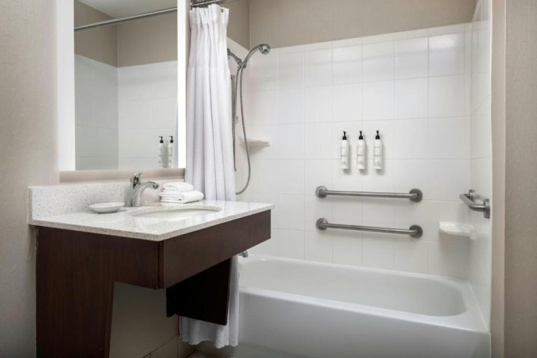 Baño accesible con bañera y barras de apoyo en SpringHill Suites by Marriott Orlando Flamingo Crossings