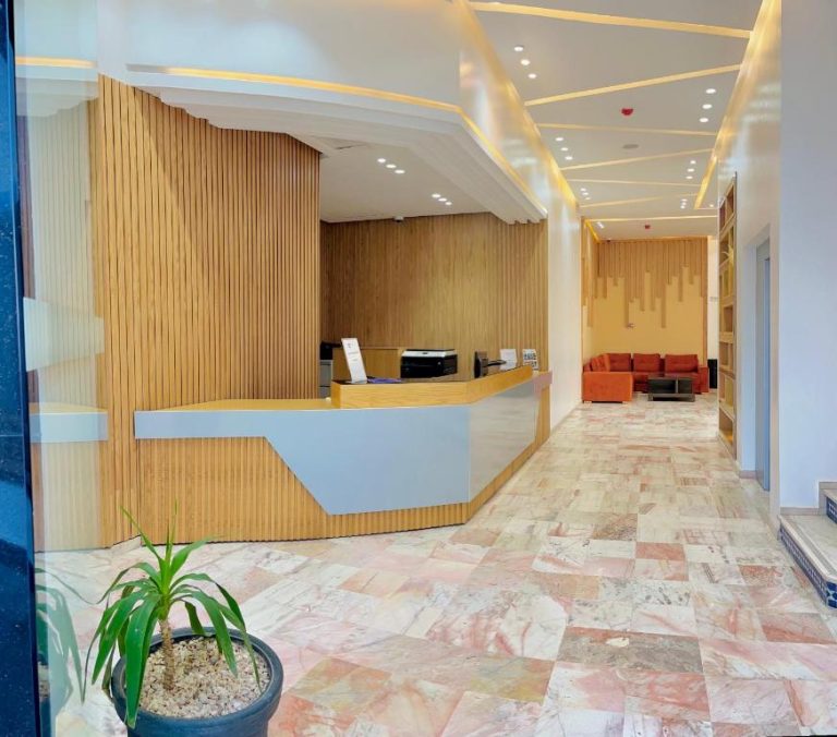 Recepción moderna con revestimiento de madera y zona de descanso en el Hotel Anna Agadir
