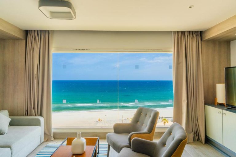 Salón con vistas al mar turquesa y playa desde ventanal panorámico en Sousse Pearl Marriott Resort