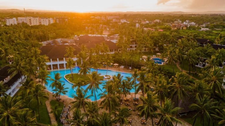 Vista aérea al atardecer de la piscina exterior rodeada de palmeras en PrideInn Flamingo Beach Resort & Spa Mombasa