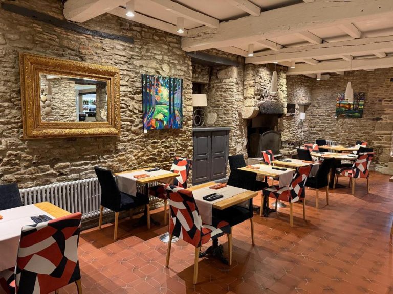 Salón comedor rústico con paredes de piedra y sillas decorativas del Hotel Restaurant Lesage