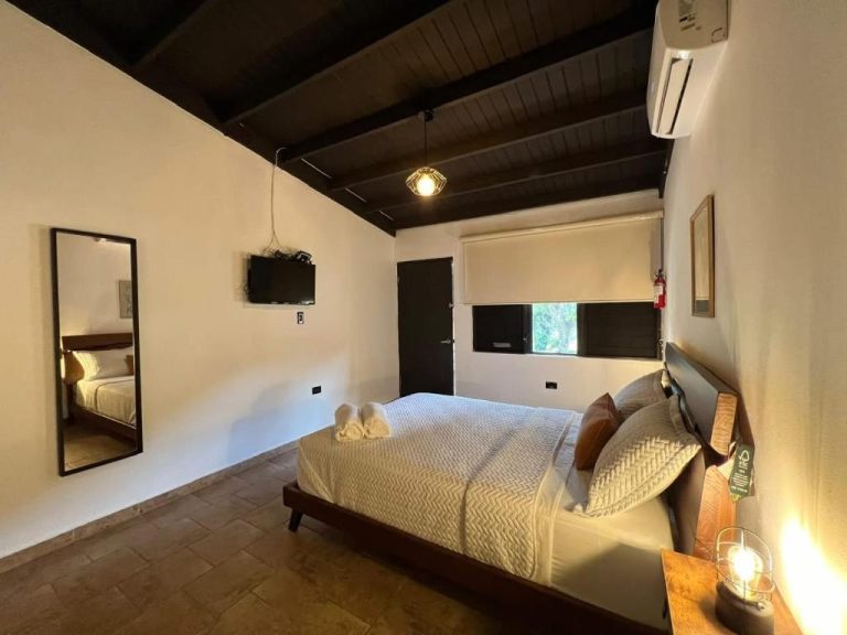 Habitación doble con cama matrimonial, techo de vigas de madera y aire acondicionado en Hacienda Villa Sotomayor