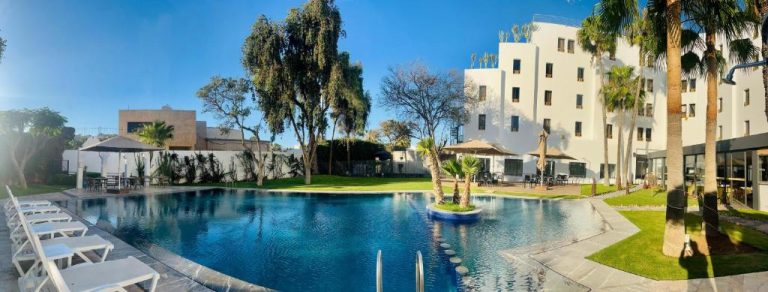 Piscina exterior con tumbonas y jardín tropical del Hotel Anna Agadir en Marruecos