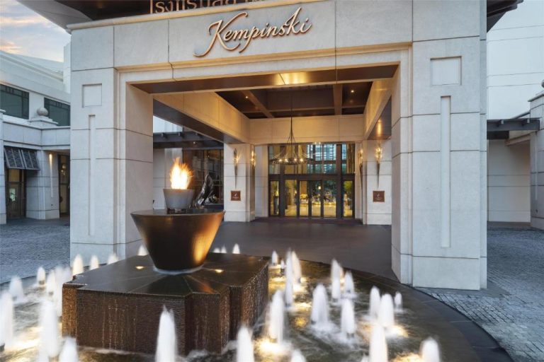 Entrada principal del Siam Kempinski Hotel Bangkok con fuente decorativa y antorcha de fuego