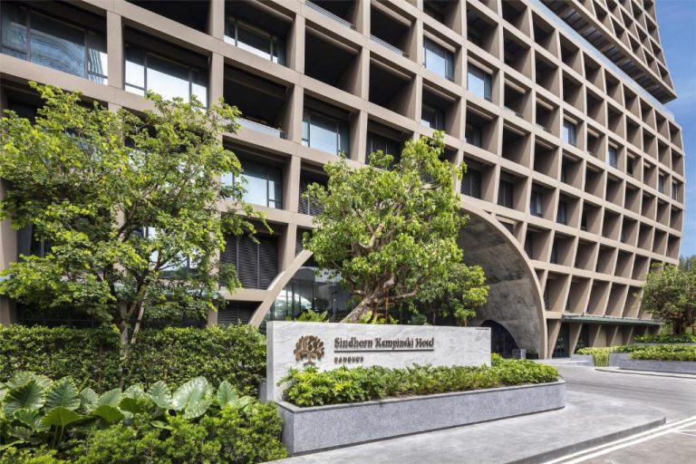 Fachada exterior del Sindhorn Kempinski Hotel Bangkok con jardines tropicales y arquitectura moderna