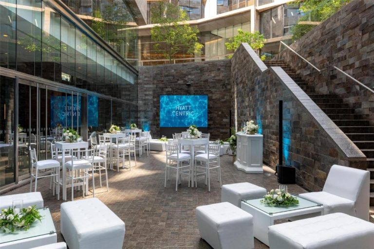 Terraza exterior para eventos con mobiliario blanco y pantalla LED en Hyatt Centric San Isidro Lima