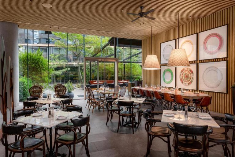 Restaurante interior del Hyatt Centric San Isidro Lima con mesas de mármol, jardín y decoración moderna