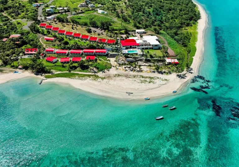 Vista aérea del hotel C Rodrigues Mourouk con bungalows de tejado rojo frente a la playa de aguas turquesas