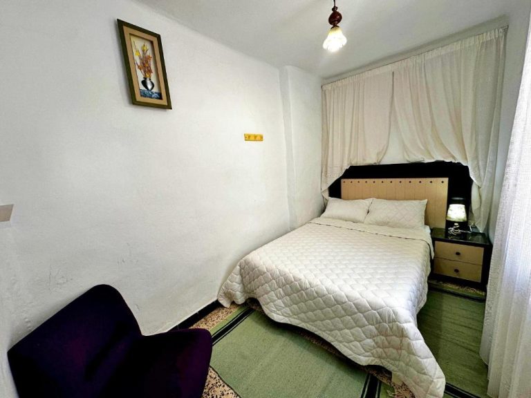Habitación doble con cama matrimonial y decoración sencilla en Hotel Paris