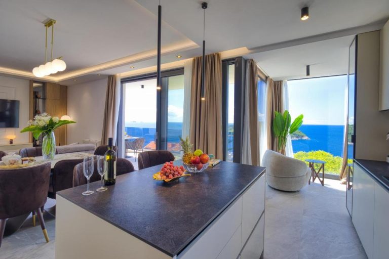 Cocina moderna con isla y vistas al mar en La Dolce Villa, con salón y terraza privada