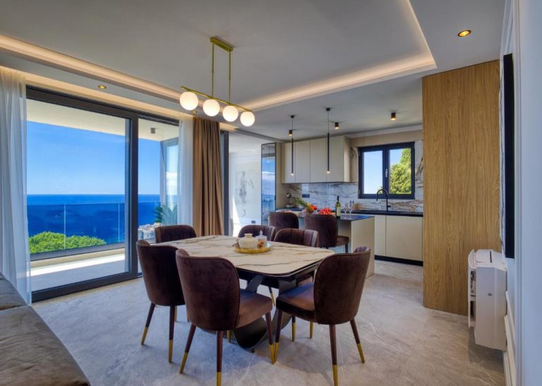 Comedor de lujo con mesa de mármol y vistas al mar en La Dolce Villa con cocina integrada