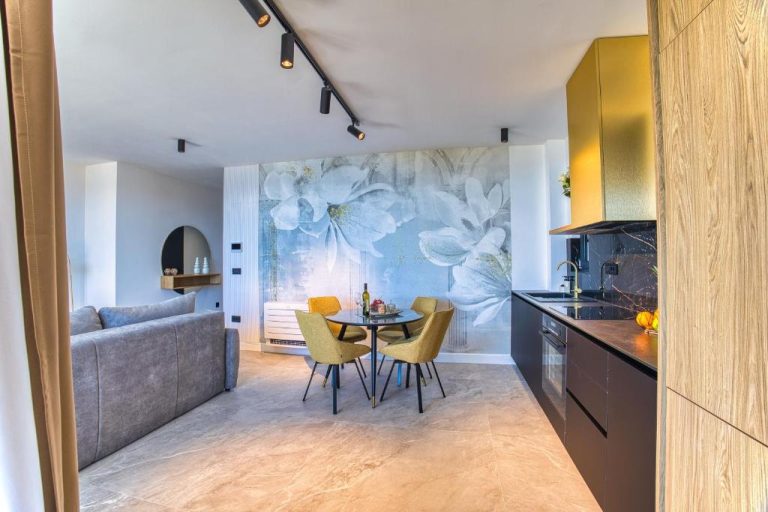 Salón comedor moderno con mural floral azul y cocina integrada en La Dolce Villa