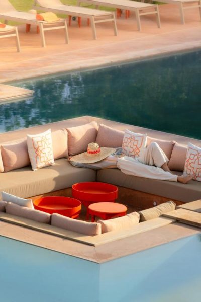 Zona chill out con sofás y cojines junto a la piscina del Maison Kenoosha Boutique Hotel & Spa