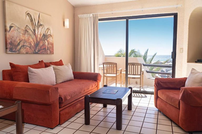 Sala de estar con sofás rojos y terraza con vista al mar en Solmar Resort All Inclusive
