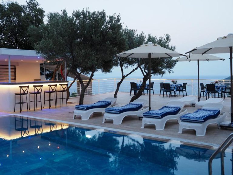 Piscina exterior con tumbonas y bar del Hotel Oliva Mare con vistas al mar al atardecer