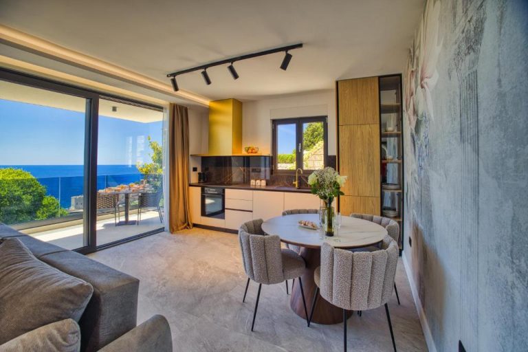 Salón comedor moderno con cocina integrada y vistas al mar en La Dolce Villa 1