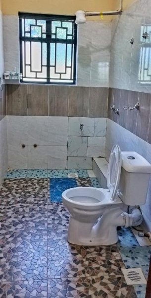 Baño completo con ducha, inodoro y suelo de mosaico en Elboran Resort and Spa