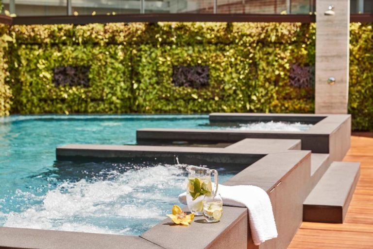 Jacuzzi y piscina exterior con jardín vertical en The Capitol Kempinski Hotel Singapore