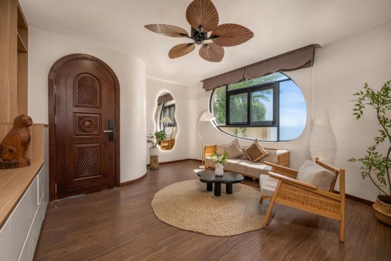 Sala de estar con diseño tropical y ventilador de techo en Saha Casa Boutique Hotel Da Nang