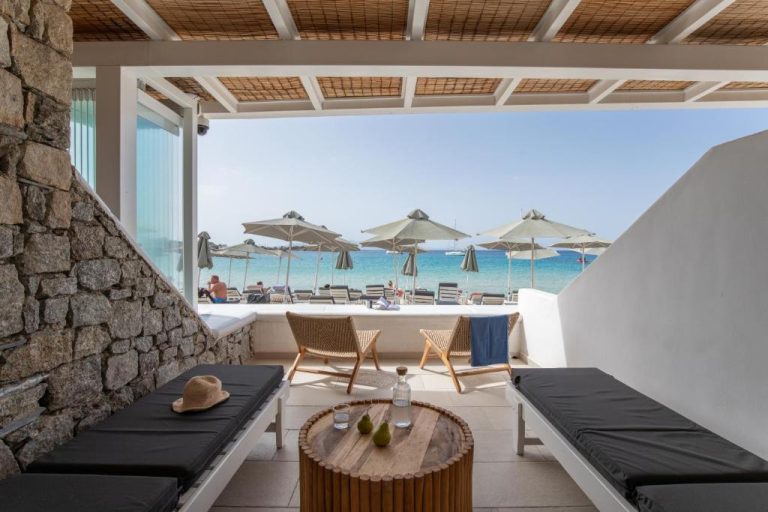 Terraza privada con vistas al mar y tumbonas del Acrogiali Beachfront Hotel Mykonos