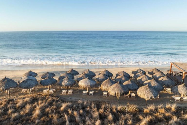 Playa privada con palapas y tumbonas del Secrets Puerto Los Cabos Golf & Spa frente al mar