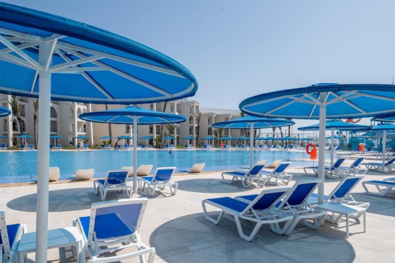 Piscina exterior con tumbonas y sombrillas azules del Pickalbatros Palais Des Roses Agadir All Inclusive