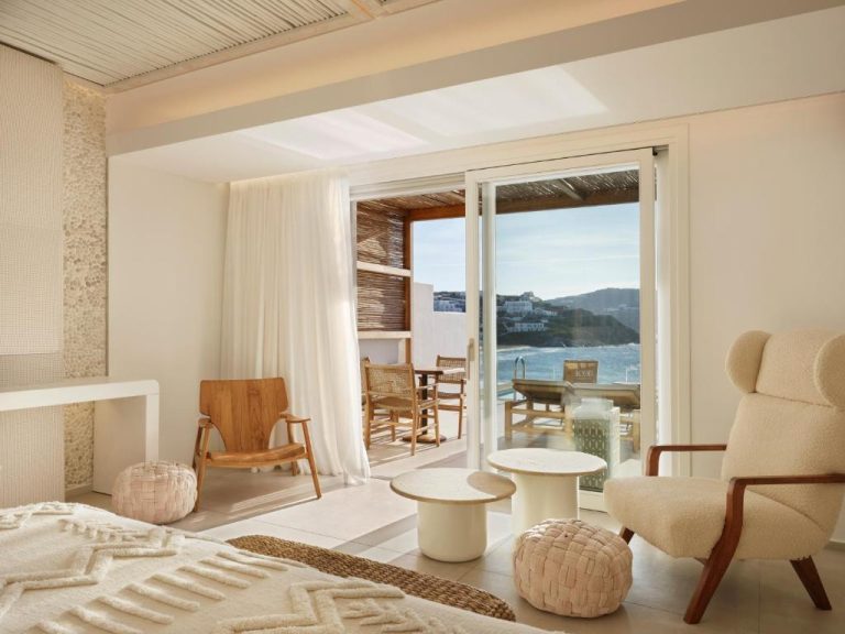 Habitación de lujo con terraza y vistas al mar en Icon Mykonos, decoración en tonos blancos y naturales