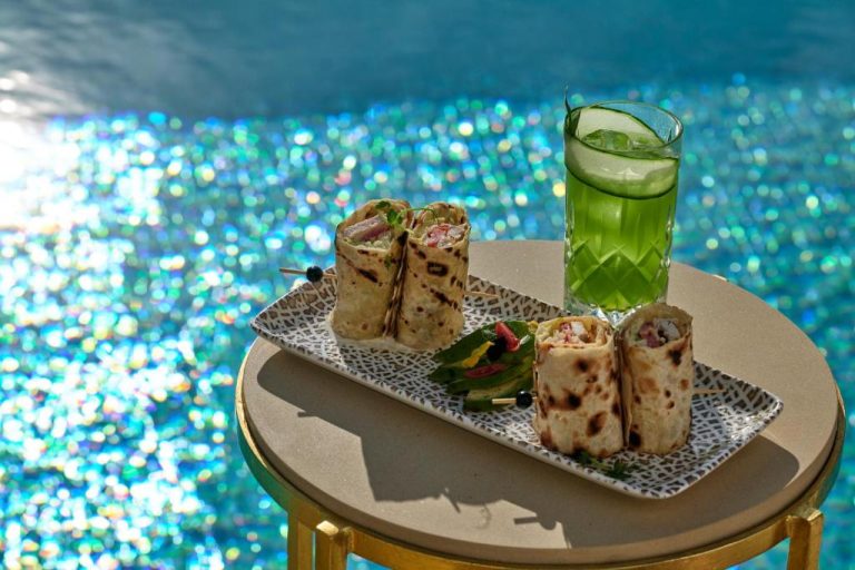 Wraps mediterráneos y cóctel verde junto a la piscina del Icon Mykonos con agua cristalina