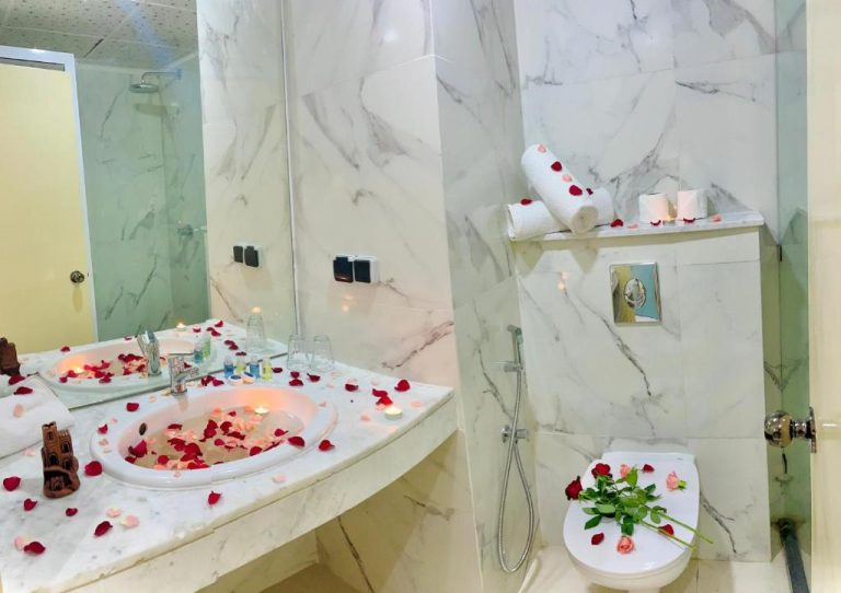 Baño romántico decorado con pétalos de rosas y velas en el Hotel Anna Agadir