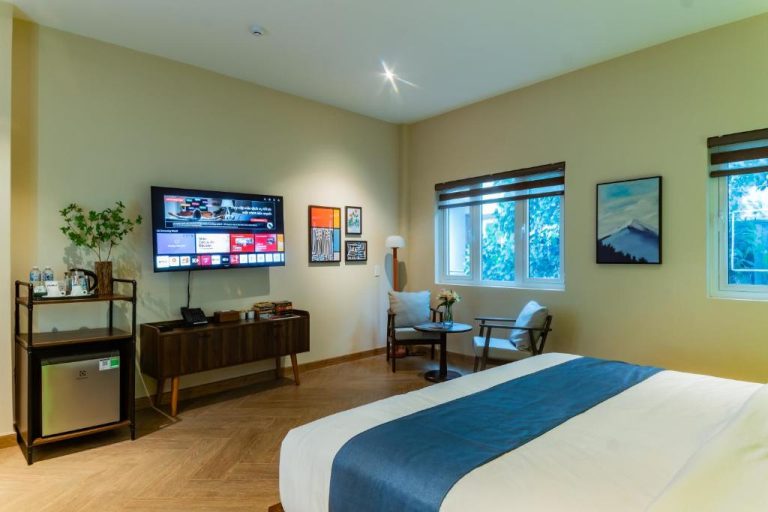 Habitación deluxe con cama doble, televisor y zona de descanso en Anise Luxe Home