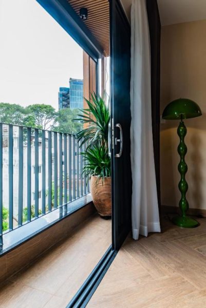 Balcón con planta decorativa y lámpara verde en Anise Luxe Home con vistas a la ciudad