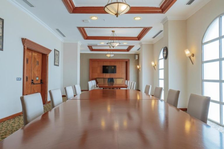Sala de reuniones con mesa de madera y sillas blancas en Pineta Park Deluxe Hotel All Inclusive