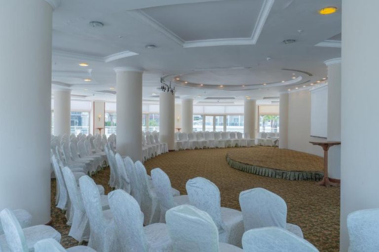 Salón de eventos y banquetes con sillas blancas y techo circular en Pineta Park Deluxe Hotel