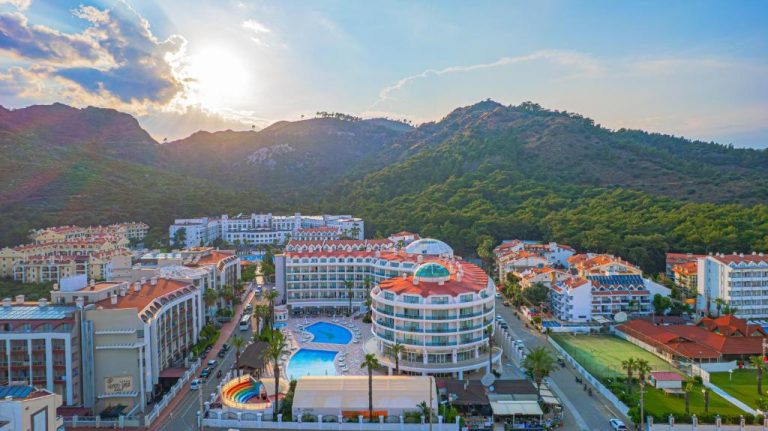 Vista aérea del Pineta Park Deluxe Hotel All Inclusive con piscina exterior y montañas al fondo